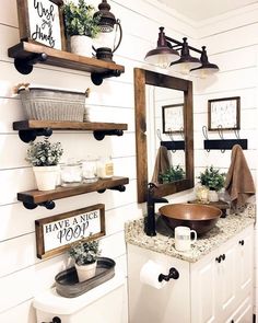 a bathroom with white walls and wooden shelves on the wall, along with two sinks