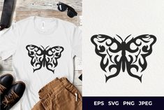 a t - shirt with a butterfly design on it and some shoes next to it