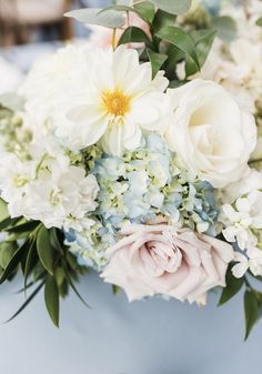 a bouquet of white and blue flowers on a table