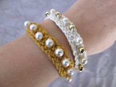 a close up of a person's arm wearing a bracelet with pearls on it