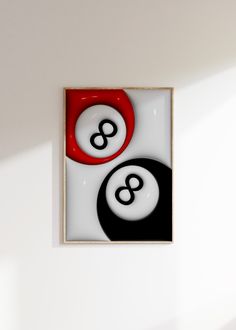 two black and white billiard balls in a square frame on the wall with sunlight coming through