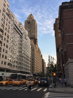 a city street filled with lots of traffic and tall buildings in the backround