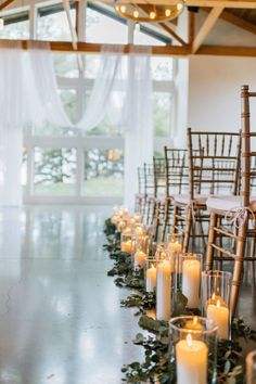 rows of candles are lined up along the aisle