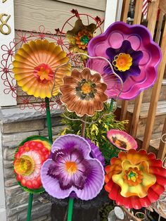 there are many colorful flowers in the flower pot on the front porch, and they look like they were made out of paper