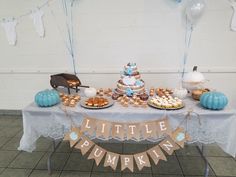 a little pumpkin themed birthday party with cake and cupcakes on a white tablecloth