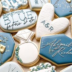 decorated cookies with blue and white frosting are arranged on a table together in the shape of hearts