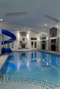 an indoor swimming pool with a slide in the middle