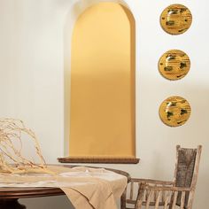 a dining room table and chairs in front of an arched window with three sun dials on the wall