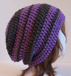 a close up of a person wearing a purple and black knitted beanie hat