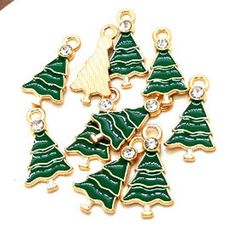 Quantity: 4 pieces for $2.95 or 10 pieces for $5.95 Material: Enamel & metal alloy & clear crystal rhinestone Shape: Tree Size: 20mm length x 11mm width. Loop is 1.5mm Color: green & gold Special Features: Charms are one sided. Great size for earrings, bracelets, or necklaces. Green enameled tree topped with clear crystal rhinestone. Colors may vary due to viewing through different monitors and screens. Photos are done from different angles and sometimes enlarged to show detail. Plea Green Dangling Charms For Gift, Green Metal Pendant Charm Necklaces, Green Charm Necklace With Dangling Charms For Gift, Green Round Charms Jewelry, Green Enamel Jewelry With Charms, Christmas Tree Charm, Tree Pendant, Christmas Charms, Tree Tops