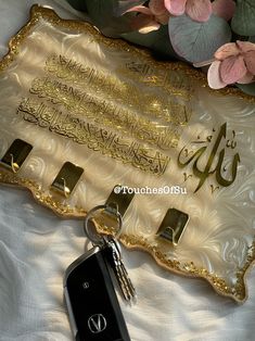 a keychain that is laying on top of a white sheet with flowers in the background