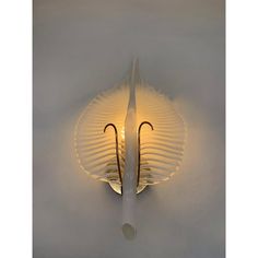 a white wall light with an umbrella design on it's side and two lights in the middle