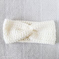 a white knitted headband with a knot on top