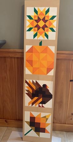 an art piece is displayed in front of a wood panel with geometric designs on it