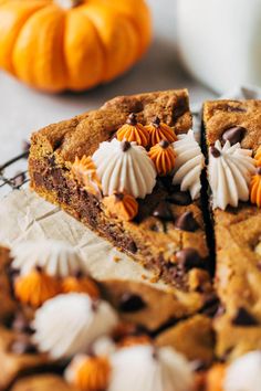 a close up of a slice of chocolate chip cookie cake with orange and white decorations