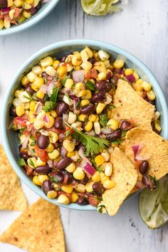 two bowls filled with corn salsa and tortilla chips