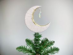 a small pine tree with a crescent hanging from it