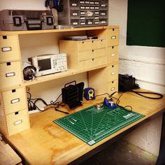 a workbench with many drawers and electronics on it