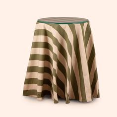 a green and white striped table cloth on top of a round table