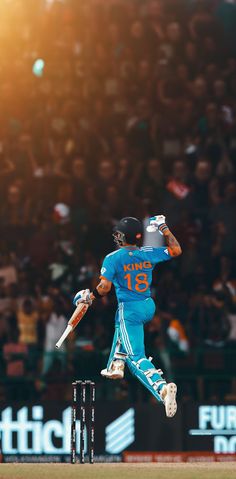 a cricket player is jumping in the air with his bat