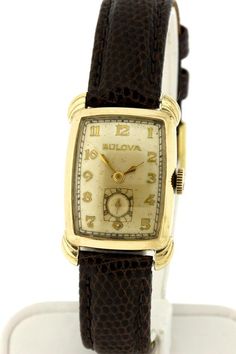 This Bulova wrist watch was made back in the 1950s and is a gold-filled case. The piece is marked 6298471. The case of the watch measures 23.2 mm wide 34.7 mm long and sets 8.47 mm tall.The gap between the lugs is 14.64 mm wide. If you would like a different strap with this feel free to contact us and we can discuss options.B2059XIPPG  --Please reference our policy for more details--***For International orders, please provide a phone number for shipping purposes. Just place a note in the comment Luxury Antique Watch With Rectangular Dial, Luxury Vintage Watch With Polished Finish, Luxury Antique Brown Watches, Luxury Vintage Rectangular Watch Accessories, Retro Rectangular Formal Watches, Retro Rectangular Watches For Formal Occasions, Retro Gold Watches With Rectangular Dial, Retro Gold Watch With Rectangular Dial, Vintage Yellow Gold Rectangular Watch