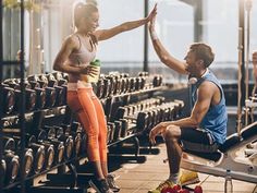 a man and woman sitting on benches in a gym with their arms around each other