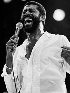 a black and white photo of a man singing into a microphone