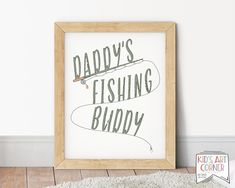 a framed poster with the words daddy's fishing buddy on it in front of a rug