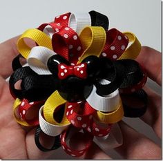 a hand holding a bunch of hair bows in it's palm and the other hand