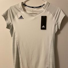 Adidas Volleyball Comfy Short Sleeve Shirt. 89% Polyester, 11% Spandex. White Adidas T-shirt With Moisture-wicking, Sporty White Tennis Tops, White V-neck Athleisure Activewear, Adidas Sports Tops With Go-dry Technology, Adidas Go-dry Sports Tops, Adidas Sporty V-neck Tops, Adidas Stretch Moisture-wicking Tops, Adidas Moisture-wicking Stretch Tops, Adidas Moisture-wicking Tops For Workout