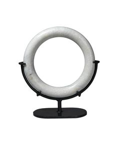 a white marble ring on a black stand