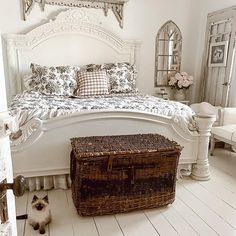 a bedroom with white walls and flooring has a basket on the floor next to the bed