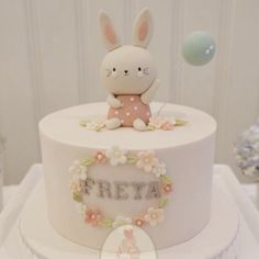 there is a white cake with a bunny on top