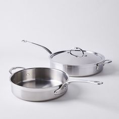 two stainless steel pots and pans on a white background