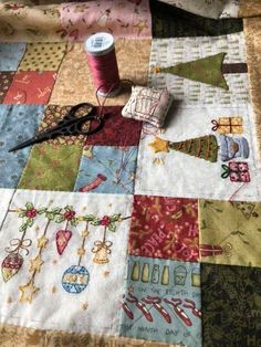 a close up of a quilt with scissors and thread