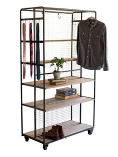 an iron and wood shelf with clothes on it