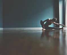 a woman sitting on the floor in front of a window