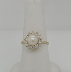 Exquisite 14k Gold Statement Ring: 7.2mm Pearl & .50ct Diamonds, Size 8.25. Discover timeless elegance with this stunning statement ring featuring a lustrous 7.2mm pearl at its center, surrounded by .50 carats of dazzling diamonds, all set in a classic basket-style design of 14k gold. Perfect for making a sophisticated statement. Classic Yellow Gold Pearl Ring With Cubic Zirconia, Classic Oval Akoya Pearl Ring, Formal Oval Pearl Ring, Formal Pearl Ring With Diamond Halo Design, Oval Brilliant Cut Pearl Ring For Formal Occasions, Oval Akoya Pearl Rings For Formal Occasions, Elegant Pearl Ring With Round Cut Center Stone, Classic Oval Pearl Ring With Center Stone, Oval Pearl Rings For Formal Occasions