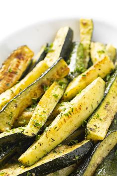 grilled zucchini on a white plate with parsley