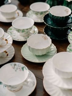 tea cups and saucers are lined up on a table