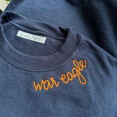 a blue t - shirt with orange lettering that says geeew on the front and back