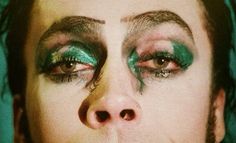 a woman with green makeup on her face