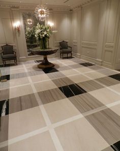 a large room with chairs and a table on the floor in front of a chandelier