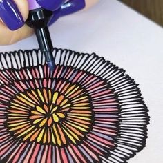 a person with purple nail polish on their nails is painting a doily ornament