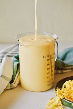 a glass measuring cup filled with yellow liquid