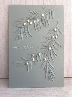 a card with some leaves and pearls on it