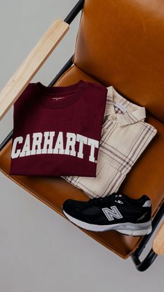 a t - shirt and pair of shoes sitting on a chair