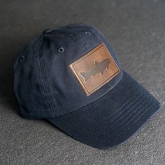 Wear your new Leather Patch Trucker Style Hat out fishing or anywhere! All hats ship for free within the USA! SPECS - Leather Patch Color Options: Natural Dublin, Nut Brown Dublin, or Cafe Chromexcel - Hat Color Options: Choose from Stone, Black, Navy, or Gray - All of our products are made to order by hand in McKinney, TX MATERIALS REAL HORWEEN LEATHER: Premium Full-Grain Leather. - Each patch is one-of-a-kind and made from part of a whole hide of leather. There will be unique variation from it Navy Adjustable Dad Hat For Outdoor, Casual Flat Bill Baseball Cap For Fishing, Fishing Snapback Hat With Curved Brim, Casual Short Brim Baseball Cap For Fishing, One Size Fits Most Snapback Fishing Cap, One Size Fits Most Snapback Fishing Hat, Adjustable Curved Brim Trucker Hat For Fishing, Adjustable Curved Brim Baseball Cap For Fishing, Curved Brim Fishing Hat