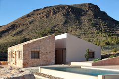 a house with a pool in front of a mountain