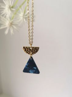 An striking, Art Deco inspired geometric necklace featuring a midnight blue triangle tortoisehell and gold plated half moon charm on a quality gold plated fine chain. This necklace comes attractively packaged with a Kaleidoscope neckalce cardholder and pouch - perfect for gifting! Dimensions: Chain length:  16 inch Charm drop: 2.5 cm Width: 1.7 cm (widest point) Key Features: Hypoallergic metal Gold Plated 1.5 mm fine chain  Lobster claw fastening Gold plated half moon brass charm Midnight blue Elegant Blue Geometric Jewelry, Modern Geometric Blue Jewelry, Modern Blue Geometric Jewelry, Blue Geometric Jewelry For Gifts, Blue Geometric Jewelry As A Gift, Blue Bohemian Jewelry With Geometric Shape, Handmade Blue Geometric Jewelry, Blue Bohemian Geometric Jewelry, Bohemian Blue Geometric Jewelry